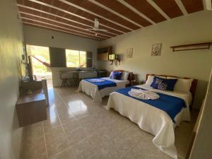 a bedroom with two beds in a room with a kitchen at Flat Térreo condomínio Pedra do Rodeaoduro in Bonito +34 photos