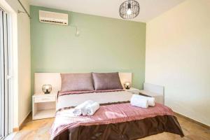 a bedroom with a bed with two towels on it at Villa Zeus Skala by Villa Plus in Mavráta +18 photos