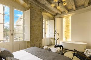 a bathroom with a tub and a bed and a bath tub at Pedra Bianca Luxury Rooms in Cagliari +38 photos