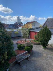 a wooden bench sitting in a courtyard with bushes at Byens Bed and Bath in Nakskov +17 photos