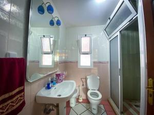 a bathroom with a sink and a toilet and a mirror at Appartement Spacieux au Centre in Chefchaouene +11 photos
