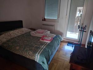 Un dormitorio con una cama con dos toallas encima. en Room in a nice sunny apartment, en Vračar (historical)