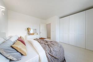 Un dormitorio blanco con una cama y armarios blancos. en DIMORA SOLARIS 6, Emma Villas, en Ugento 23 fotos más