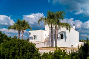 una casa blanca con dos palmeras en DIMORA SOLARIS 6, Emma Villas, en Ugento