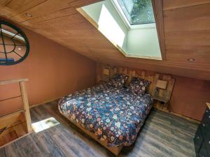 una camera da letto con un letto in una stanza con una finestra di Chambre d'Art a Friaudour