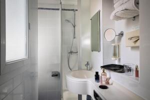 a white bathroom with a sink and a shower at Jack's Hotel in Paris +28 photos
