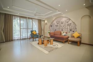 a living room with a couch and a table at VILLA M- SAVANNAH 7- 5BHK Brand New Villa in Calangute with Private Pool, Near Beach, free Breakfast, north goa in Goa