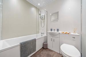 a white bathroom with a toilet and a sink at Central Kirkintilloch 2 Bed App in Kirkintilloch