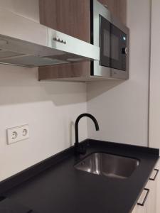 una cocina con fregadero y microondas en Apartamentos Montreal premium, en Sierra Nevada