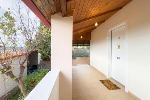 un couloir d'une maison avec des murs blancs et un plafond en bois dans l'établissement Elena's Home Apt 3, à Artemi