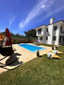 a yard with a swimming pool and a house at Villa Türkoğlu Akyaka Kuyucak Daily Weekly Rentals in Mugla