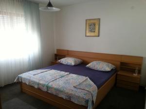 ein Schlafzimmer mit einem Bett mit zwei Kissen in der Unterkunft Apartment Jevic in Raslina