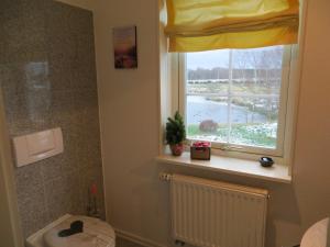 een badkamer met een toilet en een raam bij Bettis in Tostedt