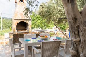 a table and chairs with a pizza oven on a patio at Villa Türkoğlu Akyaka Kuyucak Daily Weekly Rentals in Mugla