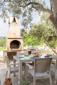 a table and chairs on a patio with a pizza oven at Villa Türkoğlu Akyaka Kuyucak Daily Weekly Rentals in Mugla