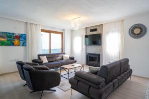 a living room with two couches and a fireplace at Villa Türkoğlu Akyaka Kuyucak Daily Weekly Rentals in Mugla