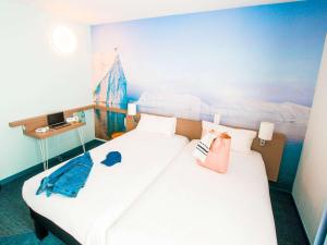 two beds in a room with a painting on the wall at ibis Styles Toulon Centre Port in Toulon