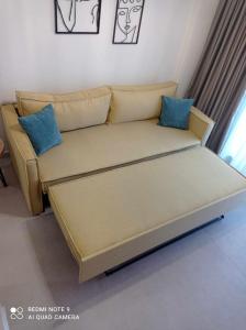 a couch in a living room with blue pillows at GeoMar Luxury Apartments in Skala Marion