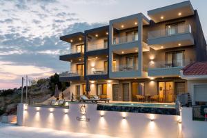 a building with a swimming pool in front of it at GeoMar Luxury Apartments in Skala Marion