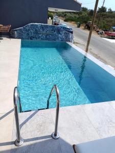 a swimming pool with a chair in front of a house at GeoMar Luxury Apartments in Skala Marion