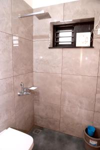 baño con ducha, aseo y ventana en ECOSTAY inn, en Sultan Bathery 26 fotos más