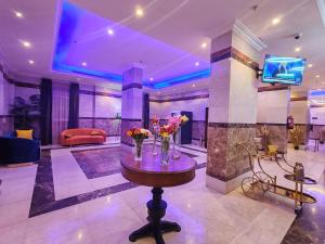 a lobby with a table with vases of flowers on it at المدى العربية للشقق المخدومة in Tabuk