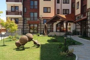 a building with a statue of balls in the grass at Aparthotel Winslow Highland in Bansko