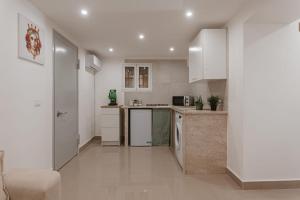 a kitchen with white cabinets and a counter top at Dimora del Moro in Palermo +15 photos