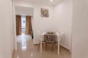 a white dining room with a table and chairs at Dimora del Moro in Palermo