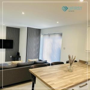 una sala de estar con un sofá y una mesa en Tastefully decorated 4 Bed Home in Gedling - Near Colwick Country Park, Victoria Retail Park, City Centre & Nottingham Racecourse, en Nottingham