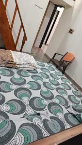 Cama en habitación con edredón verde y blanco en Adviks Home Stay, en Alibaug