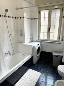 a bathroom with a tub and a washing machine at Residenza Dartuffo - Apartment - City Centre in Scilla +6 photos