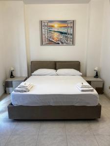 a bed in a bedroom with a picture on the wall at Residenza Dartuffo - Apartment - City Centre in Scilla