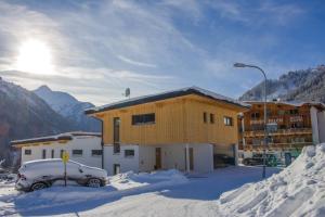 budynek z samochodem zaparkowanym na śniegu w obiekcie Ferienwohnungen Falch Simone w mieście Sankt Anton am Arlberg