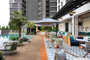 峇六拜Iconic Marjorie Hotel, Penang, a Tribute Portfolio Hotel的酒店庭院设有桌椅和游泳池。