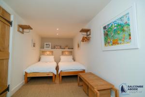 Habitación pequeña con 2 camas y banco en Hidden Treasure - Estuary View - Stylish - Garden, en Salcombe