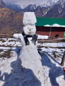 a snowman made out of snow with mountains in the background at Morning Glory Camping and trekking in Joshīmath +31 photos