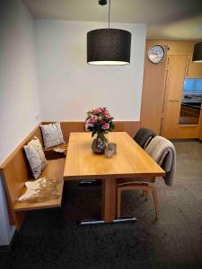 un salon avec une table avec des fleurs dessus dans l'établissement Davos Luxury Apartment - 5 Min walking to Congress Center, à Davos
