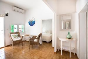 a room with two chairs and a table and a bed at Apartamentos Can Guasch Formentera in La Savina