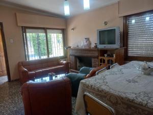 ein Wohnzimmer mit einer Couch und einem Tisch und einem Fernseher in der Unterkunft Damasco in San Rafael
