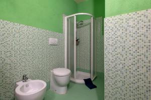 a green bathroom with a toilet and a sink at Rifugio Costiero in Cascabraga +16 photos