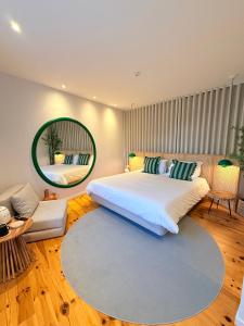 a bedroom with a large bed and a mirror at O Laranjal in Guimarães