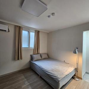 a bedroom with a bed and a lamp in it at Namsan Rooftop in Seoul