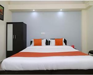 um quarto com uma cama grande com travesseiros laranja em Hotel Aditya Residency Near Sector 63 Metro Station em Noida mais 15 fotografias