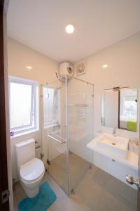 a bathroom with a toilet and a shower and a sink at 8B Flemington Colombo in Colombo