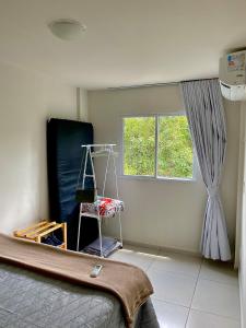a bedroom with a bed and a window and a ladder at Apartamento Lótus Ar Cond Pertinho FIG e Centro in Garanhuns