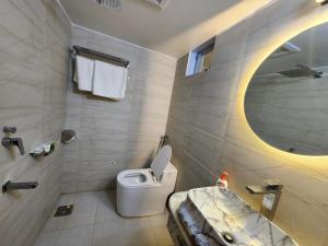 a bathroom with a toilet and a sink and a mirror at Beach Anaya Food Junction & Resort in Cox's Bazar