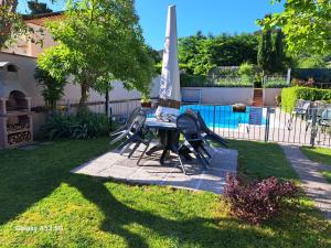 a picnic table with an umbrella in a yard at PePe house in Capannori