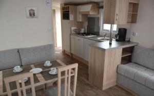 una cucina e un soggiorno con tavolo e divano di Camping Astrid a Bredene
