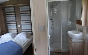 bagno con letto, doccia e lavandino di Camping Astrid a Bredene